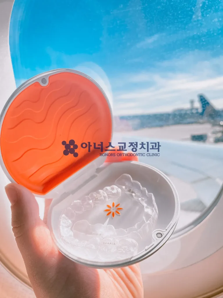 Vivera 투명 유지장치를 들고 있는 20대 여성, 밝고 깨끗한 치과 진료실 배경